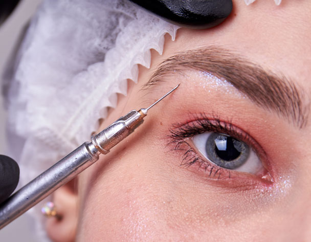 Close up of cosmetic syringe injecting in womans face. Anti wrinkle surgery.