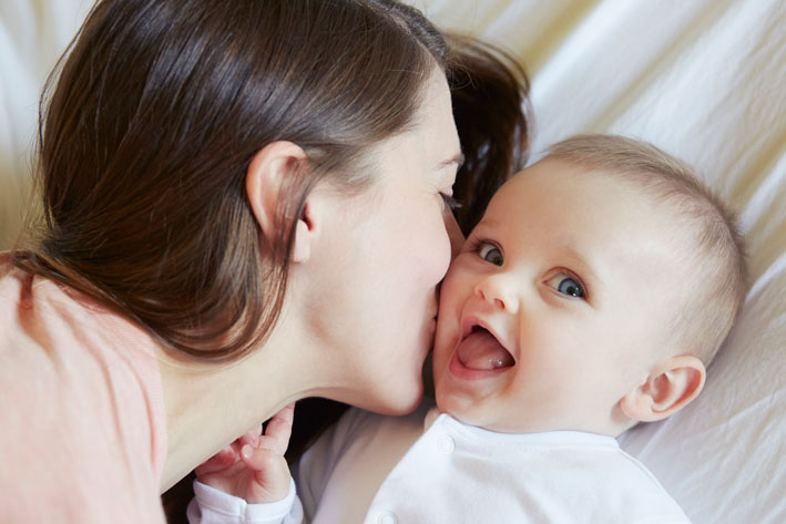 Mother cuddling with her newborn baby in the bad.